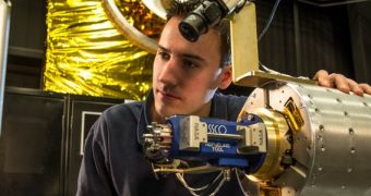 RROxiTT lead roboticist Alex Janas stands with the Oxidizer Nozzle Tool as he examines the work site