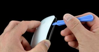iFixit prying the Magic Mouse out of its shell