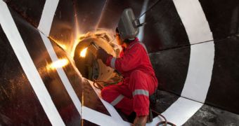 A welder works on a "reentry cone" used to guide drill pipe into the ocean floor