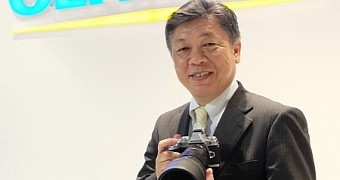 Olympus President showing off the company's gear