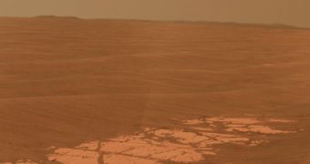 A portion of the Endeavour Crater rim about 13 kilometers (8 miles) away appears on the horizon at the left edge of this image, along with the rim of an even more distant crater, Iazu, on the right