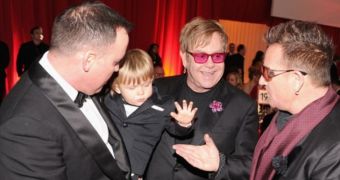 David Furnish and Elton John with their son Zachary, who is high-fiving Bono
