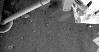The camera attached to the robotic arm reveals what appears to be rock or ice, exposed by the lander's thrusters
