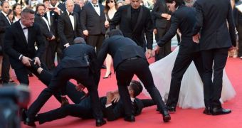 Vitalii Sediuk gets a good peek under America Ferrera's dress during a weird prank at the 2014 Cannes Film Festival