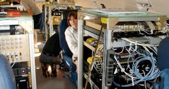 Jennifer Haase works at a bank of measurement equipment aboard a Gulf Stream V research aircraft