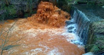 River Holme turns orange after flooding
