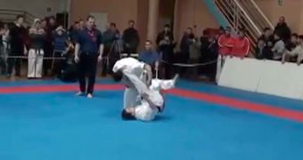 Martial arts fighter uses spinning kick to knock down opponent
