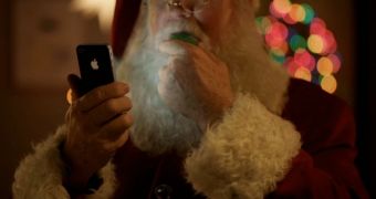 Santa Claus wielding an iPhone 4S and eating a cookie in the latest TV ad from Apple