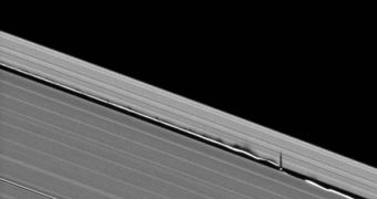 The shadows projected by Saturn's moon Dephnis are seen here projected on the dust rings (center right)