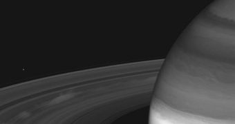 Massive, bright clouds of tiny ice particles hover above the darkened rings of Saturn in an image captured by the Cassini spacecraft on Sept. 22, 2009