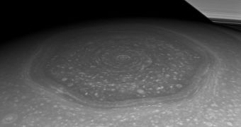 The Saturn hexagon, as seen by the Cassini spacecraft, with Saturn's rings in the background