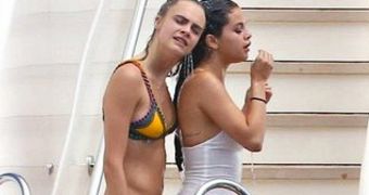 Cara Delevingne and Selena gomez, pictured here partying o a yacht, are said to have become lovers