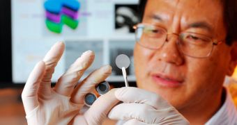Georgia Tech expert Zhong Lin Wang holds the components of a new self-charging power cell that uses piezoelectric materials to directly convert mechanical energy to chemical energy