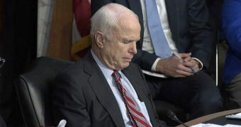 Senator John McCain plays poker during Senate Foreign Relations Committee meeting