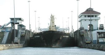 cargo ship transiting the Gatún locks northbound is guided carefully between lock chambers by "mules" on the lock walls to either side