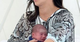 Eric, Simon Cowell's baby, looks visibly distressed in the arms of his mother as he's flown to Miami at just 10 days old