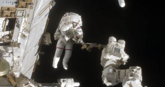 Endeavour Astronaut Dave Wolf works at the end of the International Space Station's robotic arm in a spacewalk on July 20th