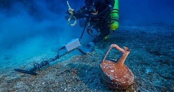 Photo shows diver Alexandros Sotiriou discovering an intact "lagynos" ceramic table jug and a bronze rigging ring on the Antikythera Shipwreck