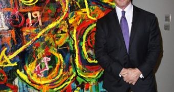 Sylvester Stallone standing in front of one of his recently displayed paintings