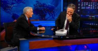 Jon Stewart can't stop laughing at the sound of Isaacson's remarks regarding Gates' embarrassing attept to sell a portable music player that would compete with the iPod