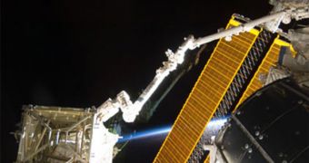 The S6 truss (lower left) rests at the end of Canadarm2, the International Space Station's robotic arm