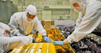 Engineers blanketing key electronics on the NASA James Webb Space Telescope with thermal insulators