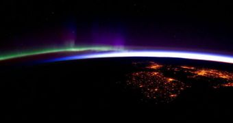 This image shows portions of Ireland and England, the sunrise in the background, and bright auroras to the left