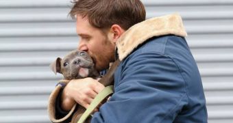 Tom Hardy cuddles a pup on the set of a new movie