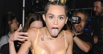 Miley Cyrus poses backstage after her much derided performance at the MTV VMAs 2013