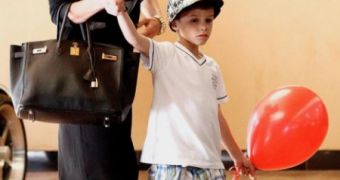 Victoria Beckham trying to keep her balance on heels while visiting a theme park with her children