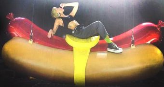 Miley Cyrus is sucking her thumb while riding a giant hot dog for her latest concert