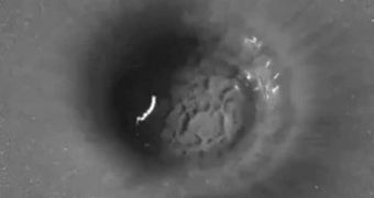 Photo showing a crater formed after a water drop impacted a grain target