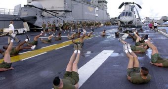 US Marines start  their morning with group exercises on the flight deck aboard USS Bataan