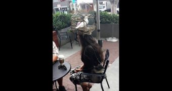 Woman wears live bird locked in cage on her head
