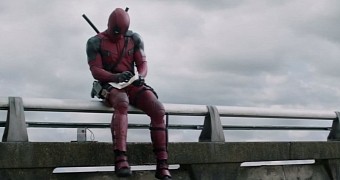 Deapool chills on a bridge on the side of the road in first official “Deadpool” trailer