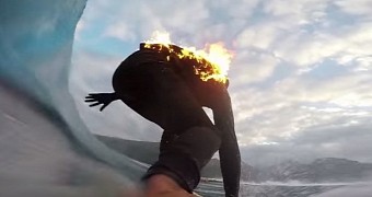 Surfer rides wave while on fire