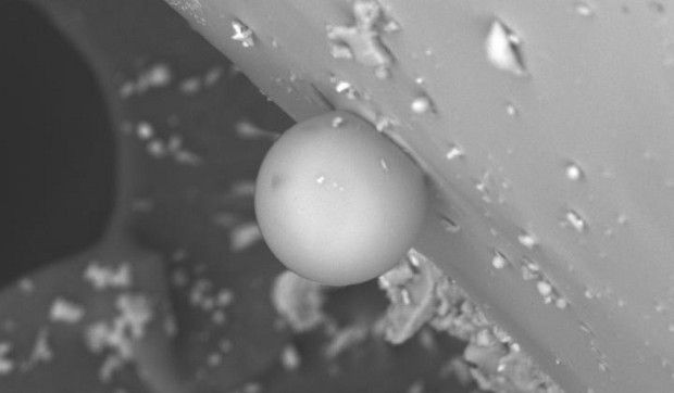 Photo shows a miniature glass sphere obtained in the lab