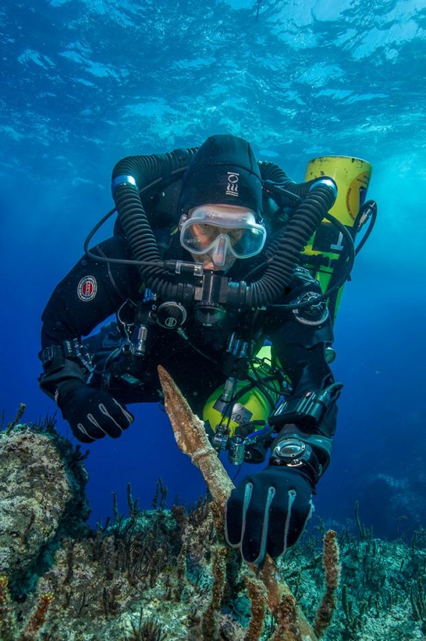 Diver Philip Short pictured inspecting the bronze spear recovered from the Antikythera Shipwreck