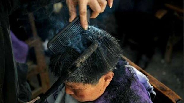 Barber in China uses hot metal tongs to cut hair