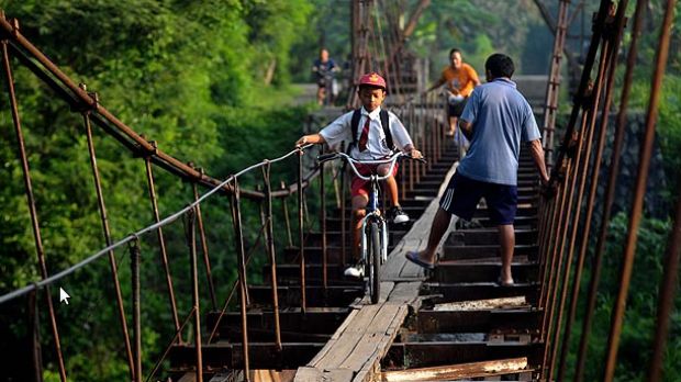Children cycle to school on suspended aqueduct