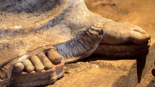 Ancient sculptures stand tall on platform sandals