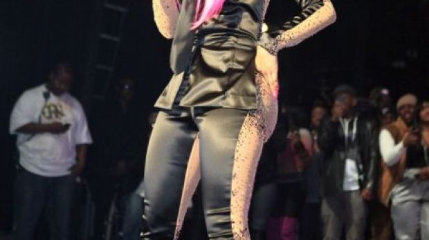 Nicki Minaj in concert, sporting a two-faced suit