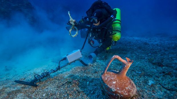 Photo shows diver Alexandros Sotiriou discovering an intact "lagynos" ceramic table jug and a bronze rigging ring on the Antikythera Shipwreck