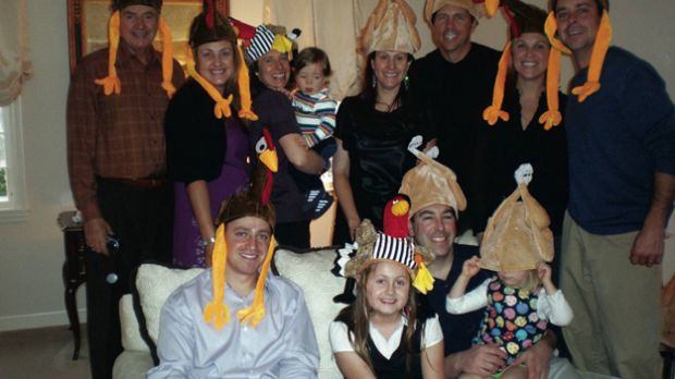 Family wearing turkey hats for Thanksgiving photo
