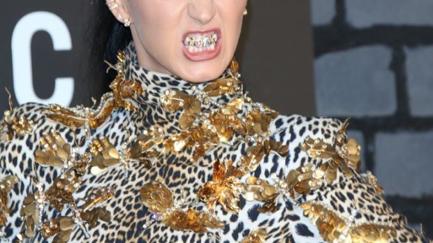 Katy Perry promotes her new single with a rainbow colored, diamond grill