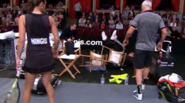 Sir Elton John goes down with his chair, feet up in the air, at charity tennis match