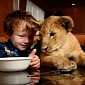Picture of the Day: Lion Cub Joins Boy and Girl for Breakfast