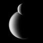Rhea Backdropped by Titan in New Cassini Image