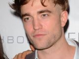 Robert Pattinson is still rocking his trademark messy hair, or at least a part of it