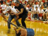 White Rihanna gets tossed on the floor by white Chris, at high-school pep rally